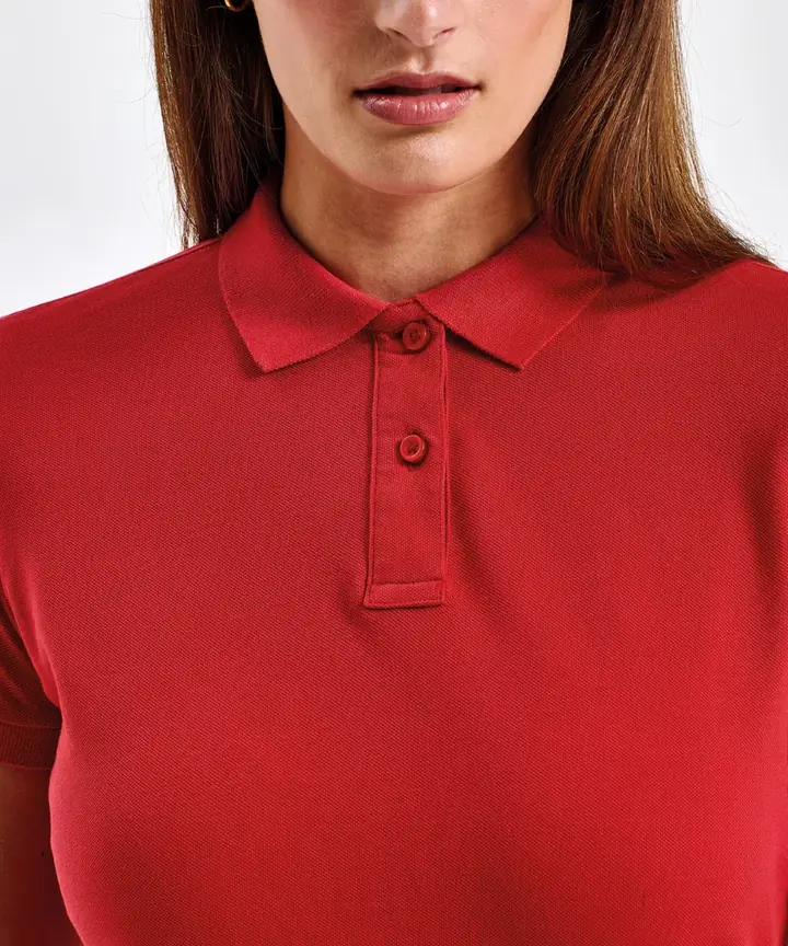 Gros plan sur la patte de boutonnage d'un polo femme rouge